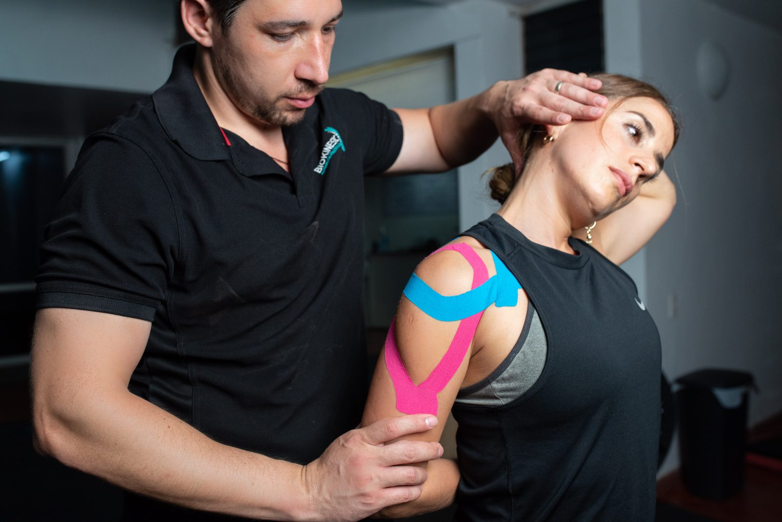 Terapeuta de BIOKINESIC aplicando vendaje neuromuscular a una paciente